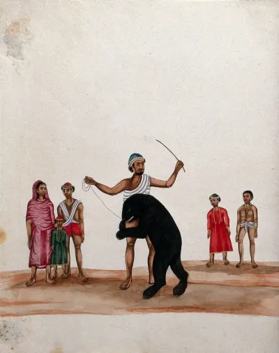 A man with his performing bear watched by a group of people