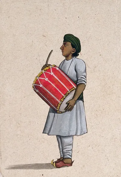 A musician playing a dholka (folk drum)