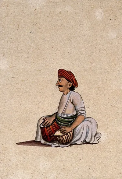A musician playing a tabla (a pair of drums)