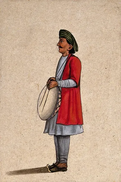 A musician playing an Indian percussion instrument, similar to the dhap