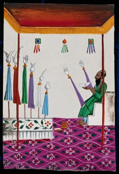 A Muslim man sitting on a step under a canopy decorated with pennants