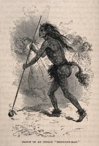 A native American medicine man with elaborate body painting performing a dance