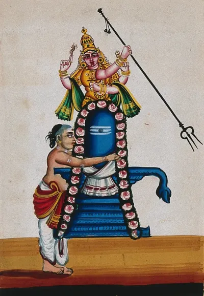 A priest decorating the Shivalingam which also has a statue of Lord Shiva behind it