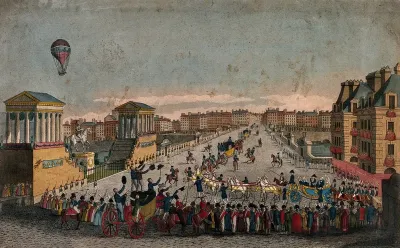 A procession of carriages watched by crowds lining the streets, with soldiers on parade: a hot-air balloon flies overhead