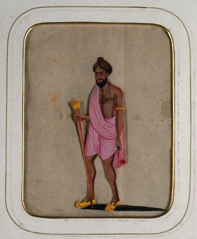 A sanyasi with a pink cloth draped around him carrying a staff