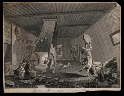 A shaman banging a drum and dancing invoke spirits to cure a sick man