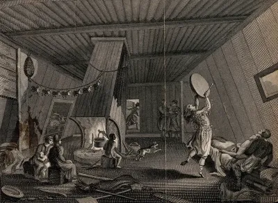 A shaman banging a drum and dancing to invoke spirits to cure a sick man