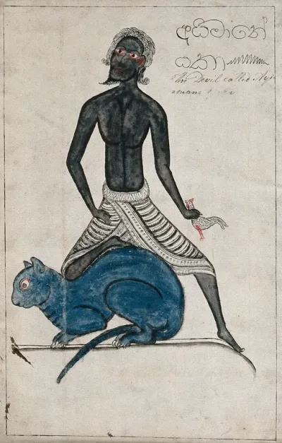 A Sinhalese black devil called Ayimane holding a cockerel in one hand and resting a leg on a giant blue cat