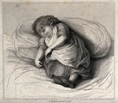 A small child asleep leaning against a pillow
