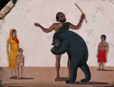 A street entertainer making a bear perform