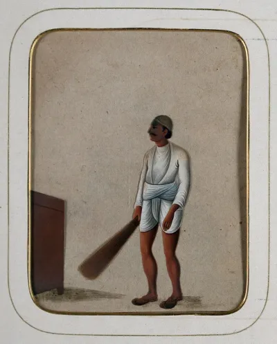 A sweeper holding a jhadu (broom)