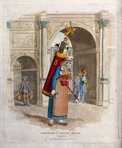 A vendor of lemonade and barley water in Paris is carrying a large drinks container on her back as she walks through the street