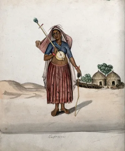 A village woman carrying a musical instrument in one hand, a stick with a small bowl in the other and a baby tied up in a bundle on her head