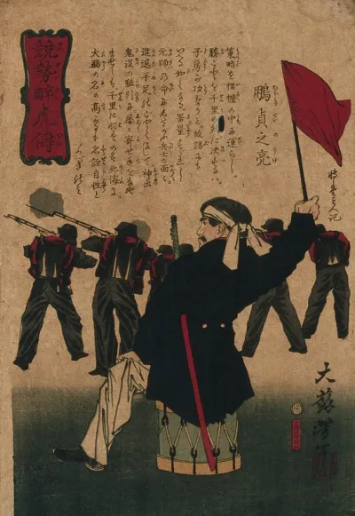 A warrior holding a flag seated on a drum, with troops firing in the background