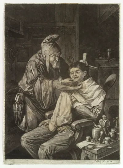 A wizened old barber who wears a pointed hat is shaving a young man