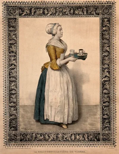 A woman carrying a cup of chocolate and a glass on a tray
