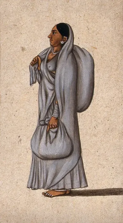 A woman carrying two cloth bundles, one slung over her right shoulder and the other in her left hand