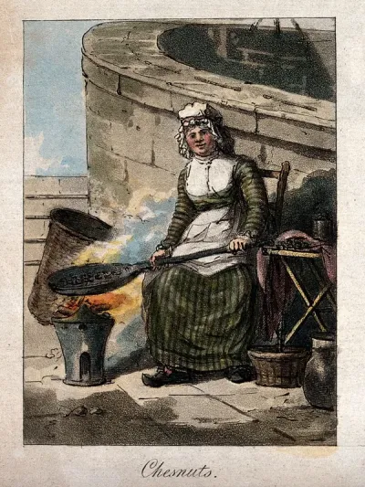 A woman holds a pan of chestnuts over a blazing brazier