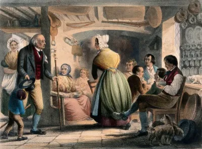 A woman is drawing up a chair for a gentleman who has joined a group of people sitting in a kitchen area