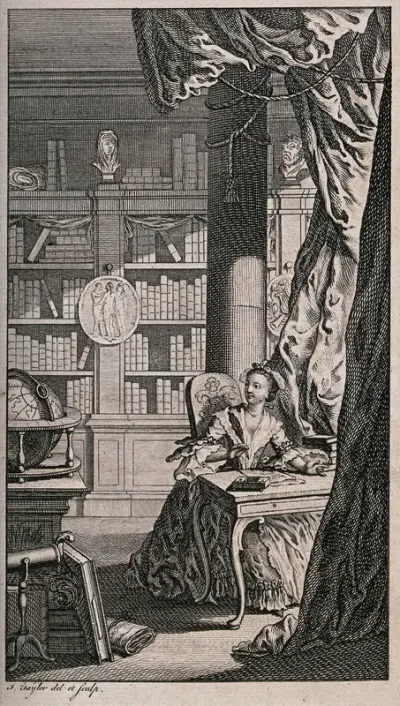 A woman is sitting at a desk in a library, writing