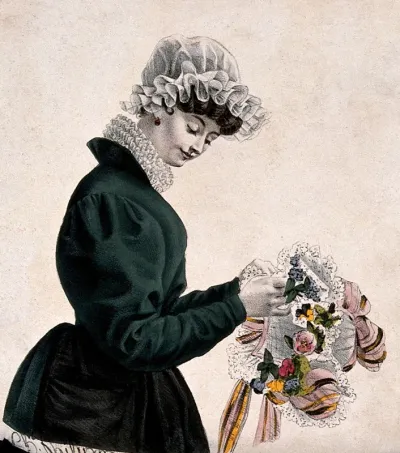 A woman is tying ribbon and lace around a posy of flowers