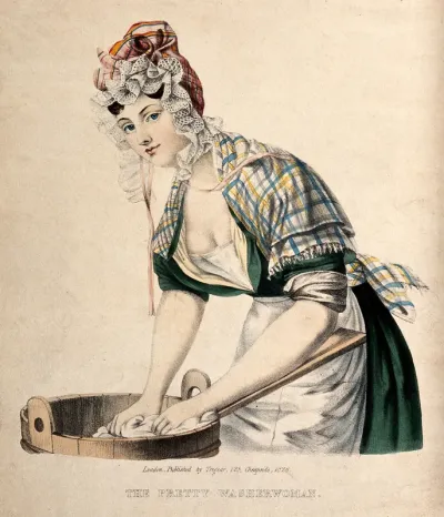 A woman is washing clothes on a wash board at a tub