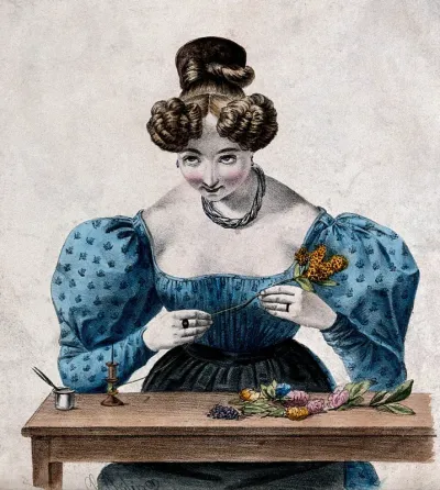 A woman is winding cotton around the stems of flowers