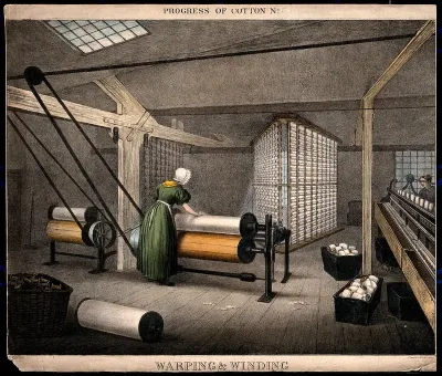 A woman is working at large rollers winding cotton onto reels