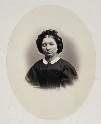 A woman's head and shoulders, her right eyelid is heavier than her left