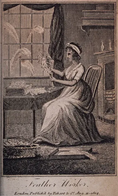 A woman sits working with baskets and boxes of feathers