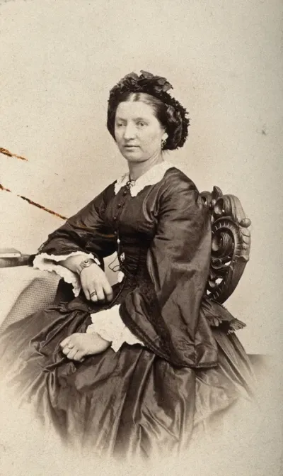 A woman sitting down, her right eyelid is heavier than her left