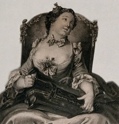 A woman sitting in a chair playing the hurdy-gurdy and looking towards a man on her left