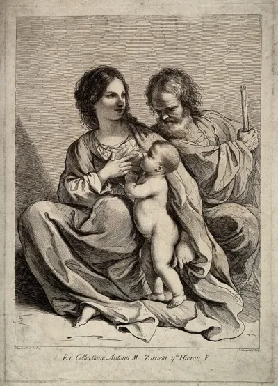 A woman sitting next to her husband and breast feeding her child