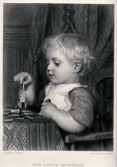 A young child sitting at a table using dominoes as building blocks