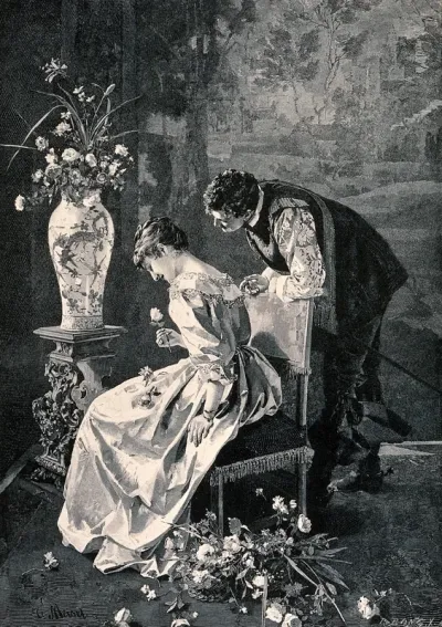A young man leans over the back of the young woman's chair and she is smiling as she holds the flower in her hand