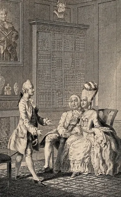A young man stands in front of an older couple with his hands extended