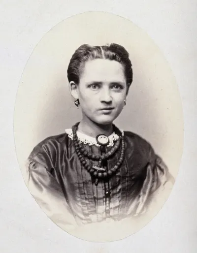 A young woman, head and shoulders; her face is slightly contorted