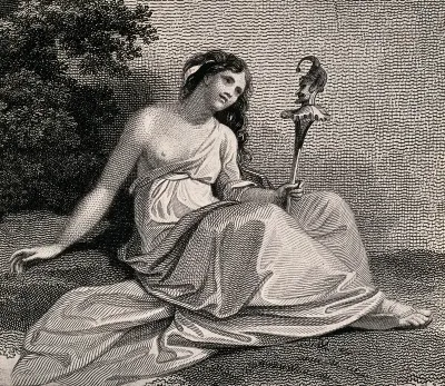 A young woman sits holding a puppet of Punchinello in her hand