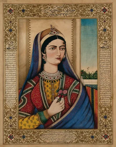 An European (?) woman wearing Indian clothes and jewellery sitting on a chair, holding a flower