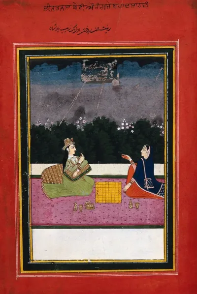 An Indian lady sitting and playing a game with another woman