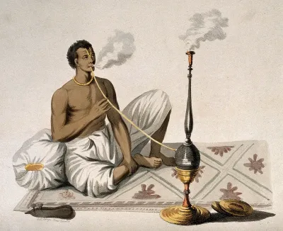 An Indian man smoking a nariel, or cocoa nut hooka