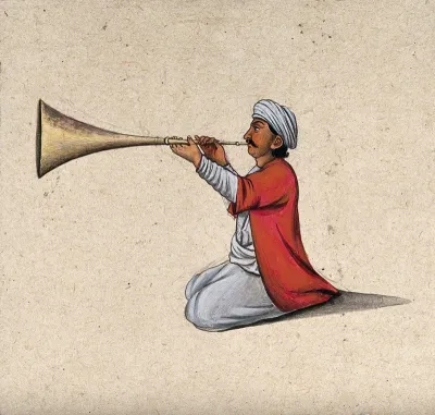 An Indian musician playing a brass wind instrument