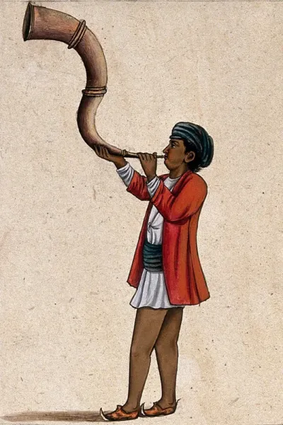 An Indian musician playing a long, inverted 's' shaped trumpet