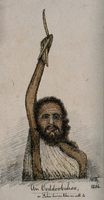 An Indian sadhu with very long fingernails is holding his arm up above his head