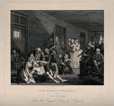 An insane man (Tom Rakewell) sits on the floor manically grasping at his head, while two attendants manacle his legs: his lover, Sarah Young, cries in distress, they are surrounded by lunatics at Bethlem hospital, London