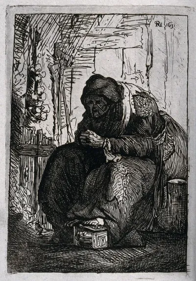 An old woman sits crouched with her foot on a tin