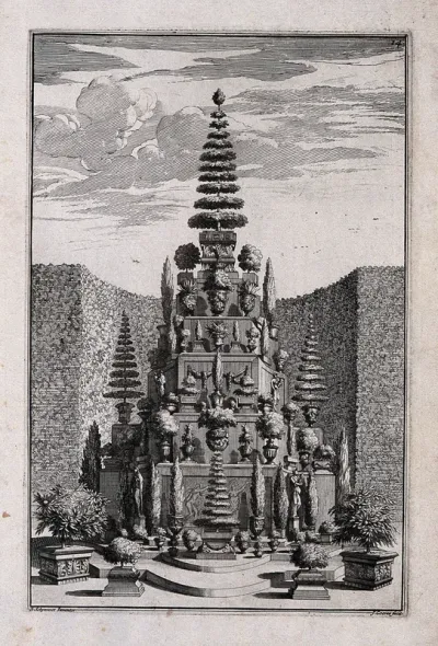 An ornate garden obelisk decorated with trees and shrubs in vases