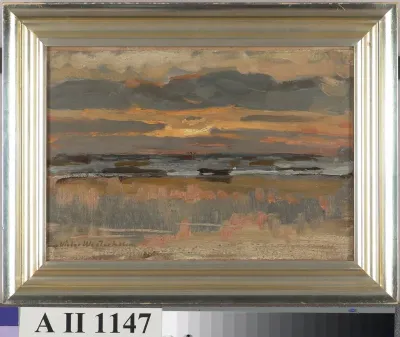 Aurinko laskee pilveen merenrannalla