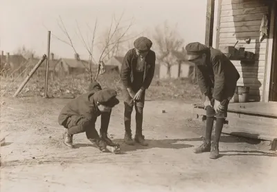 Brantley Henson (boy near porch). Been in mill 8 years. Jasper Henson, (in middle) Been in 3 years. Thedie Miller (Shooting). Been in 3 years. All doffers. Salisbury Cotton Mills, North Carolina
