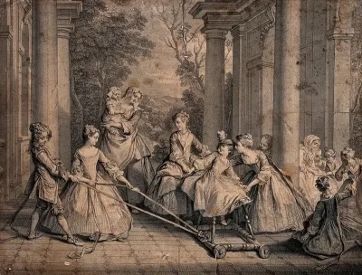Children playing a game with one of them being pulled along on a baby-walker with ribbons